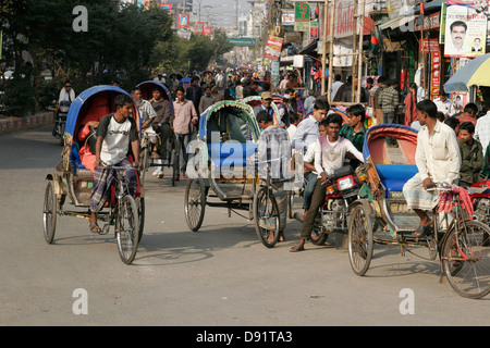 Rikschas, die Passagiere auf der belebten Straße Bogra, nördlich von Bangladesch Stockfoto