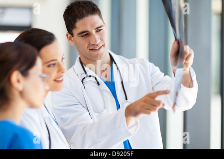 Gruppe von Angehörigen des medizinischen Personals des Patienten Röntgenfilm betrachten Stockfoto