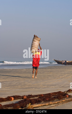 Asien, Indien, Goa, Benaulim, ein Fischer trägt leer fischen Körbe auf seiner Schulter Stockfoto