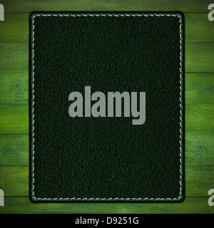 grünem Leder Hintergrund mit weißer Naht auf Holzbohlen grau Stockfoto