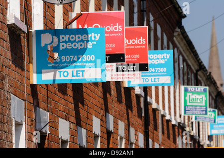 Häuserzeile mit vielen "zu verkaufen" und "lassen" Immobilienmakler Zeichen Stockfoto