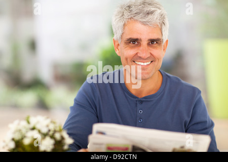 Porträt von reifer Mann liest Zeitung zu Hause Stockfoto