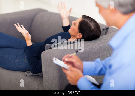 mittlere gealterte Frau am Sofa liegen und im Gespräch mit ihr Psychologe Stockfoto