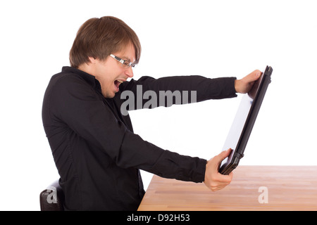 Wütende junge Geschäftsmann will seinen Laptop auf dem Tisch zu zerstören. Isoliert auf weißem Hintergrund. Stockfoto