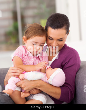 glückliche Mama spielt Puppe mit Töchterchen auf sofa Stockfoto