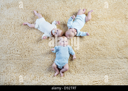 Bildung von drei Babys auf Teppich Verlegen Stockfoto