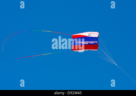 Handtasche Drachen Rot weiß und blau Höhenflug vor lebendigen Himmel Stockfoto