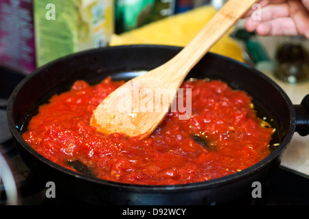 Tomatensauce in Pfanne mit Holzspatel Stockfoto
