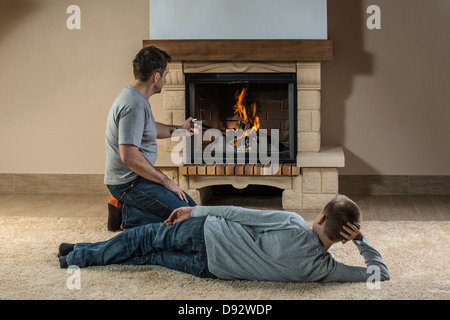 Vater und Sohn entspannende neben Feuer Stockfoto