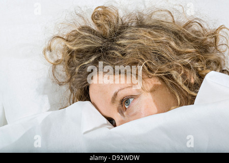 Tagträumen Frau im Bett unter weißen Decke Stockfoto