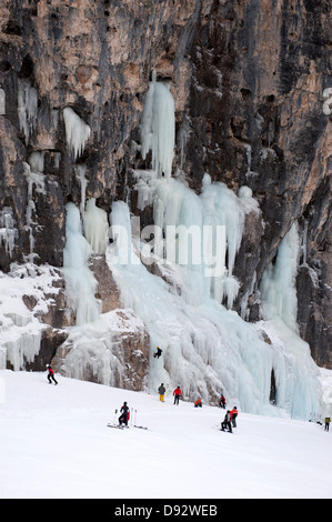 Skifahrer beobachten Eiskletterer auf Felswand am Lagazuoi, Südtirol, Italien Stockfoto