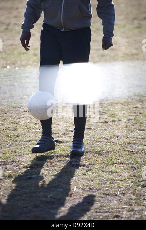 Ein junger Mann einen Fußball-Ball in einem park Stockfoto