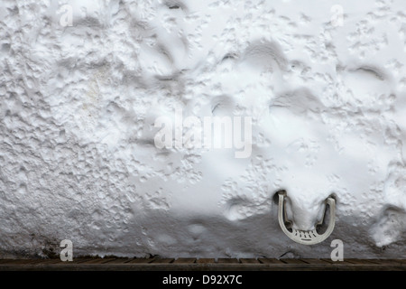 Ein Kunststoff Liegestuhl im Schnee in einem Hinterhof begraben Stockfoto