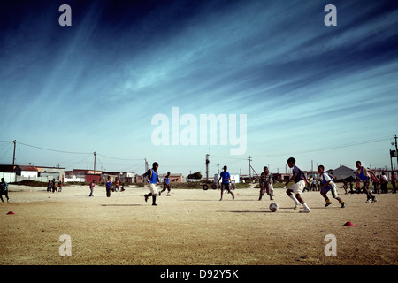 Afrikanischen jungen Fußball spielen sie während der Schulferien lernen Fußball-Fähigkeiten in Khayelitsha Süden trainiert werden Stockfoto