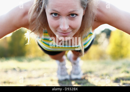 Junge Frau tut Push Ups Stockfoto