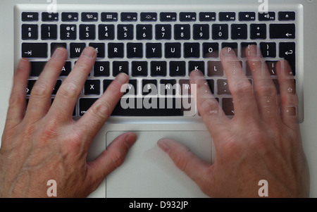 Hände auf einem Apple Macbook pro Laptop Computer-Tastatur. Stockfoto