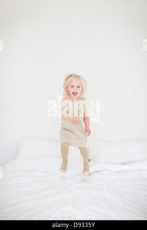 Kleines Mädchen springen auf Bett Stockfoto