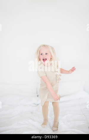 Kleines Mädchen springen auf Bett Stockfoto