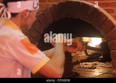 10. Juni 2013 - arbeitet Gaza-Stadt, Gazastreifen, Palästinensische Autonomiegebiete - palästinensischen Basem Shnar in seinem kleinen Restaurant in Gaza-Stadt, am 10. Juni 2013. Shnar, ein Palästinenser, der in Syrien lebte, bevor der Konflikt stattfand, jetzt verdient seinen Lebensunterhalt durch den Verkauf von Gebäck mit syrischen Aromen und Gewürze im Gaza-Streifen (Credit-Bild: © Mohammed Asad/APA Images/ZUMAPRESS.com) Stockfoto