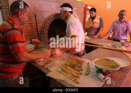 10. Juni 2013 - arbeitet Gaza-Stadt, Gazastreifen, Palästinensische Autonomiegebiete - palästinensischen Basem Shnar in seinem kleinen Restaurant in Gaza-Stadt, am 10. Juni 2013. Shnar, ein Palästinenser, der in Syrien lebte, bevor der Konflikt stattfand, jetzt verdient seinen Lebensunterhalt durch den Verkauf von Gebäck mit syrischen Aromen und Gewürze im Gaza-Streifen (Credit-Bild: © Mohammed Asad/APA Images/ZUMAPRESS.com) Stockfoto