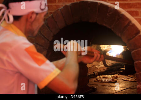 10. Juni 2013 - arbeitet Gaza-Stadt, Gazastreifen, Palästinensische Autonomiegebiete - palästinensischen Basem Shnar in seinem kleinen Restaurant in Gaza-Stadt, am 10. Juni 2013. Shnar, ein Palästinenser, der in Syrien lebte, bevor der Konflikt stattfand, jetzt verdient seinen Lebensunterhalt durch den Verkauf von Gebäck mit syrischen Aromen und Gewürze im Gaza-Streifen (Credit-Bild: © Mohammed Asad/APA Images/ZUMAPRESS.com) Stockfoto