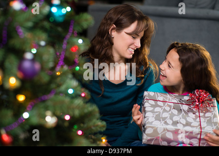 Hispanische Mutter und Tochter Weihnachtsgeschenke zu öffnen Stockfoto