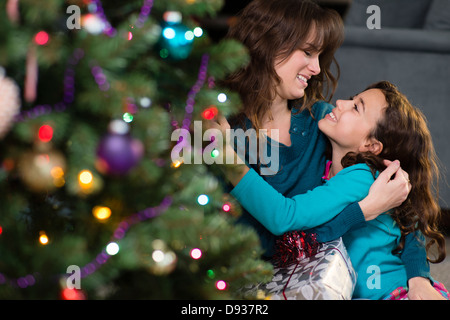 Hispanische Mutter und Tochter von Weihnachtsbaum Stockfoto