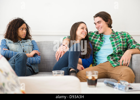 Paar ignorieren Freund auf sofa Stockfoto