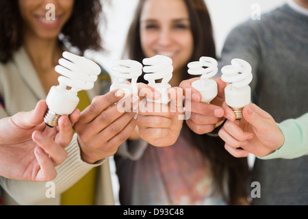 Freunde halten Leuchtstoff Glühlampen Stockfoto