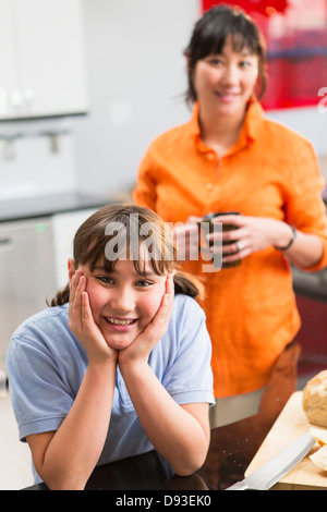 Mutter und Tochter lächelnd in Küche Stockfoto