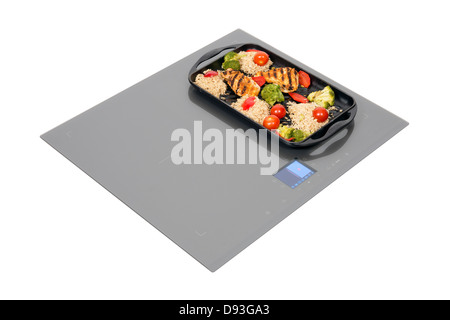 Grauglas Induktions-Kochfeld mit Brathähnchen isoliert auf weiss. Stockfoto