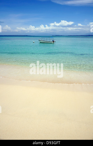 Tropischen Sandstrand mit klarem Wasser und einem Boot allein in der Karibik Stockfoto