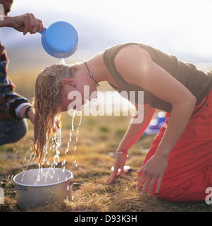Junge Frau, die Haarwäsche, Seitenansicht Stockfoto