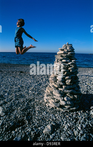 Eine Frau an einem Strand springen. Stockfoto