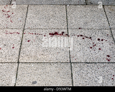 frische Blutflecken auf einem Pflaster aus der vorherigen Nächte Alkohol angeheizt Gewalt vollgespritzt Stockfoto