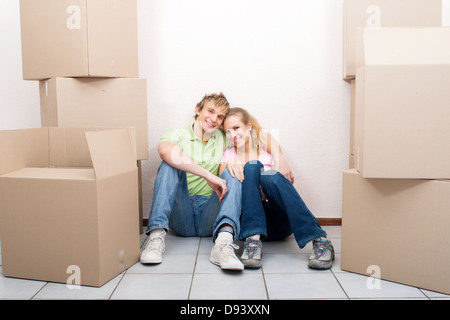 glückliches junges Paar auf neue Heimat Boden sitzend Stockfoto