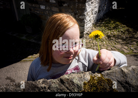 Junges Mädchen betrachten Blume Löwenzahn Stockfoto