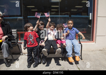 Gruppe von Kindern, Fahnen in der Hand, sehen die Memorial Day Parade in Bay Ridge, Brooklyn, NY. Stockfoto