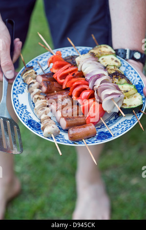 Mann-Betrieb-Spieße auf Platte Stockfoto