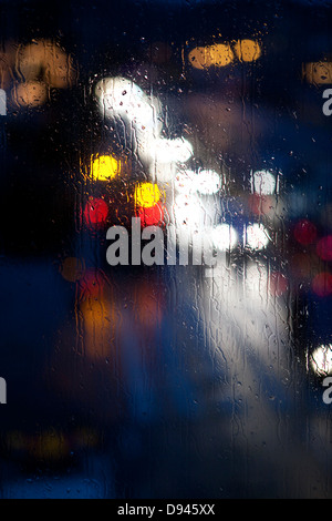 Lichter, die durch Regen Glas gesehen Stockfoto