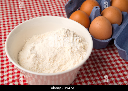Mehl und Eiern am Küchentisch, Rohkost-Zutaten. Stockfoto