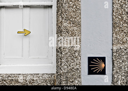Richtungsanzeiger des Camino de Santiago in der Fassade eines Gebäudes Stockfoto