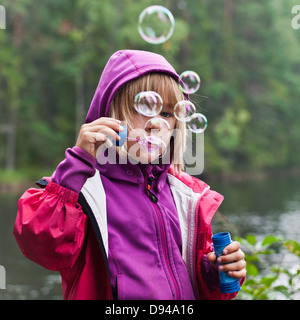 Mädchen bläst Luftblasen im freien Stockfoto