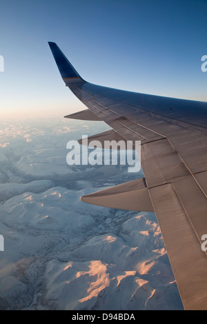 Flugzeug fliegen über schneebedeckte Berge Stockfoto