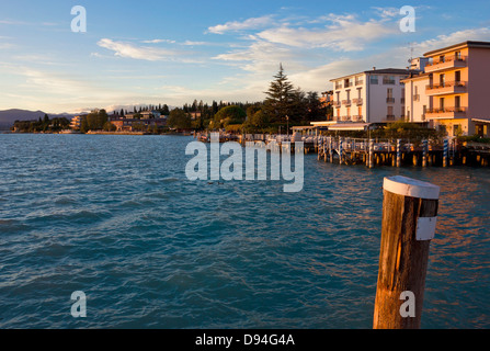 Sonnenuntergang den Landungsbrücken Hafen und Sirmione Uferpromenade am Lago di Garda, Italien. Warmes Licht über die Landschaft am Gardasee. Stockfoto