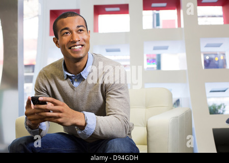 Schwarze Geschäftsmann mit Handy im Büro Stockfoto