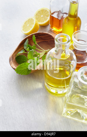 Zweig Zitronenmelisse in eine Schüssel geben, Kräutern, Zitrone und Flaschen von ätherischen Ölen Stockfoto