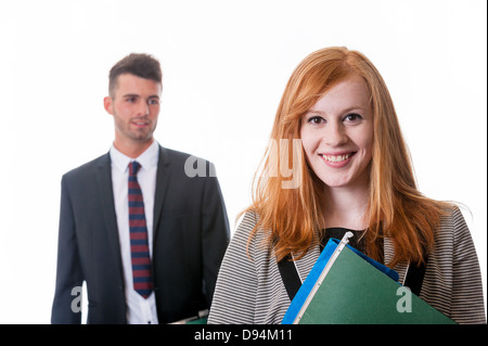 Sicher glücklich Geschäftsfrau mit Ordnern und Geschäftsmann im Hintergrund auf weiß Stockfoto