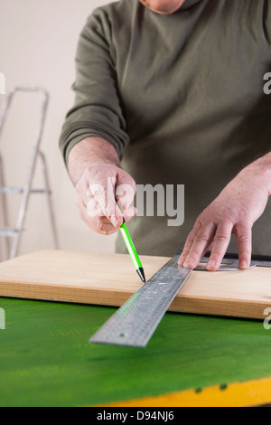 Mann, die Messung von Holz, Holz-Projekt im Studio Stockfoto