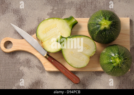 Draufsicht der Runde Zucchini auf Schneidebrett mit Messer, ein Schnitt in Hälfte Stockfoto